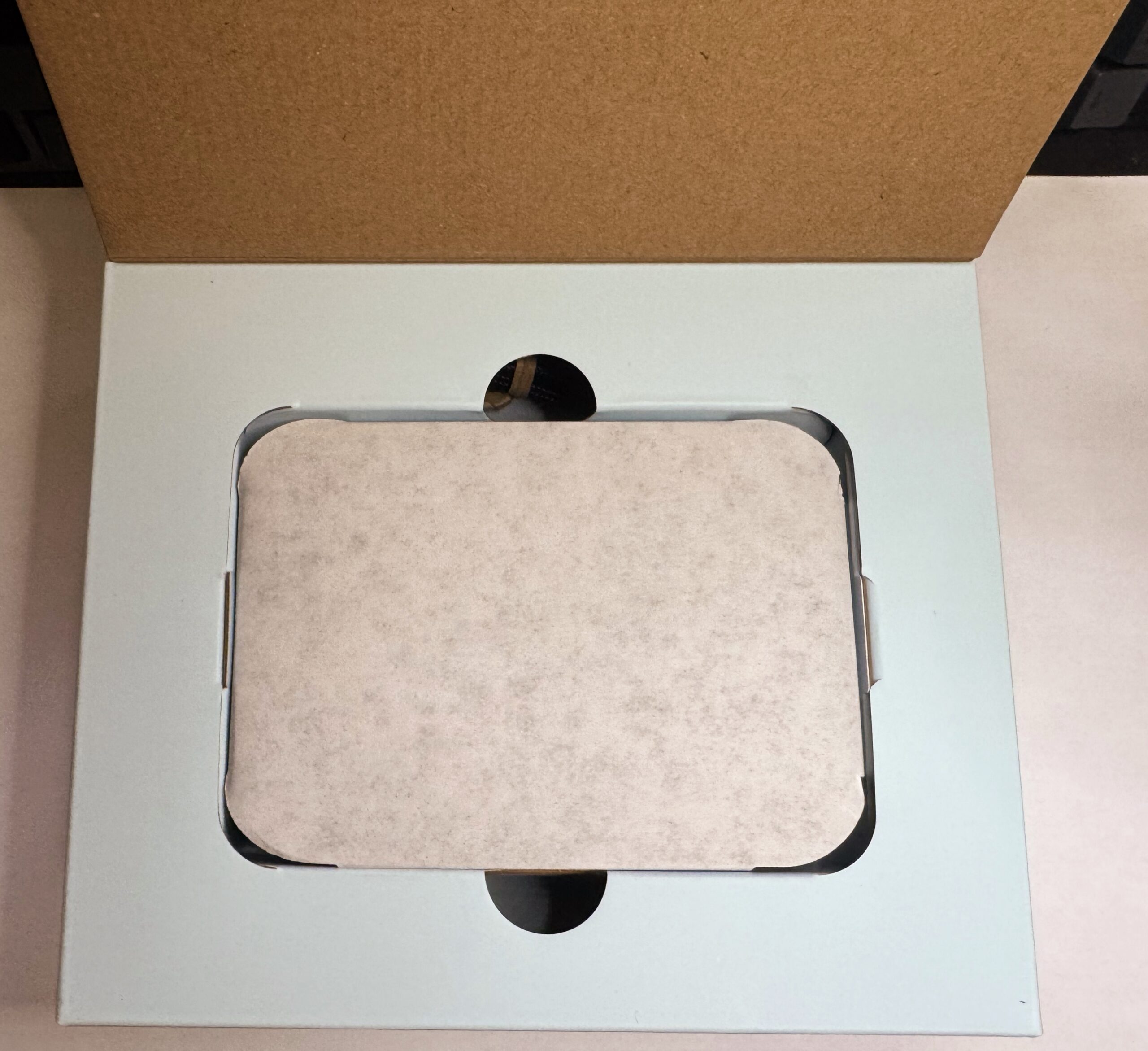 Stream Deck Neo 外箱を開けたところ。中に薄紙に包まれた本体が入っています。